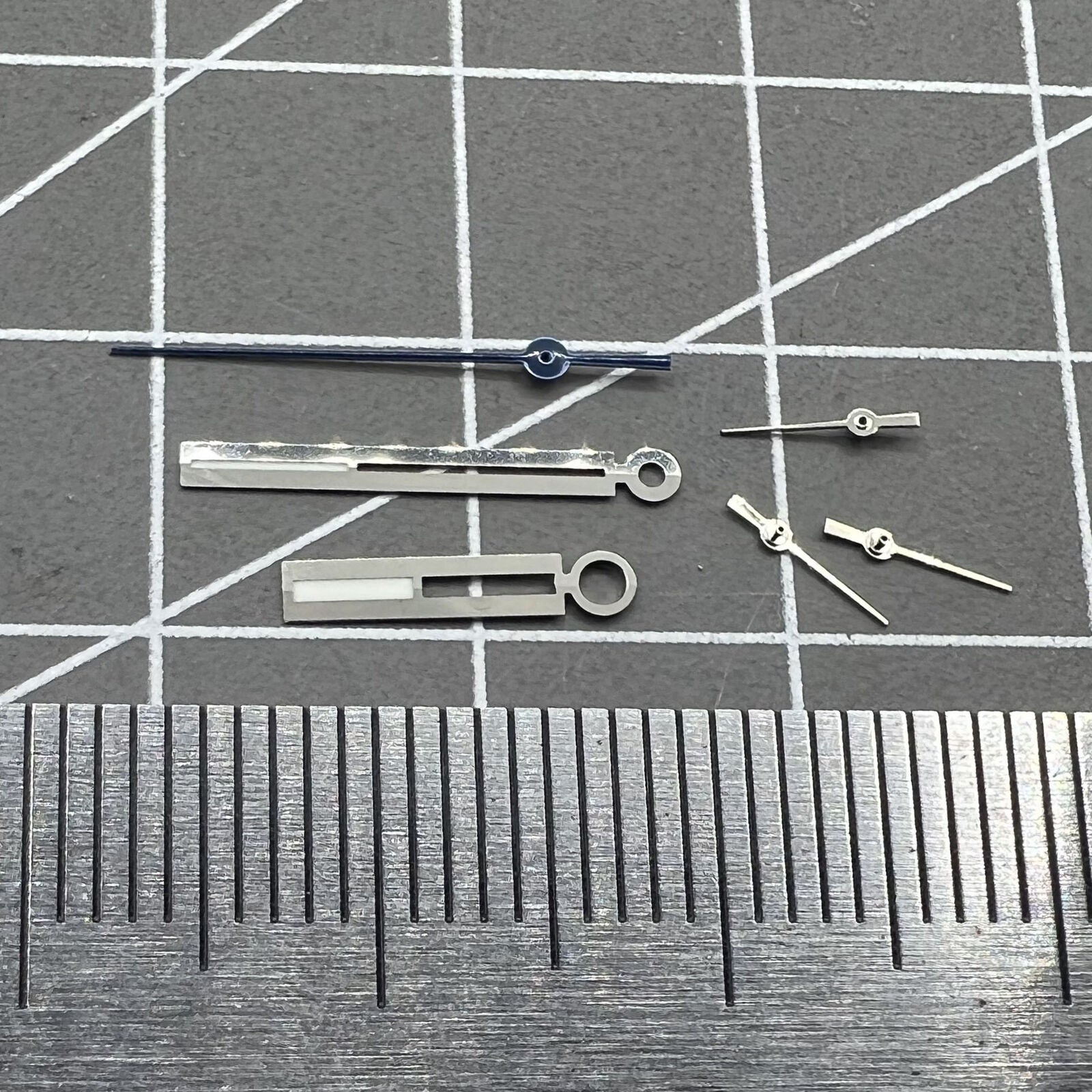 Luminous silver watch hands for Ronda 5021D quartz movement, enhancing readability in low light.