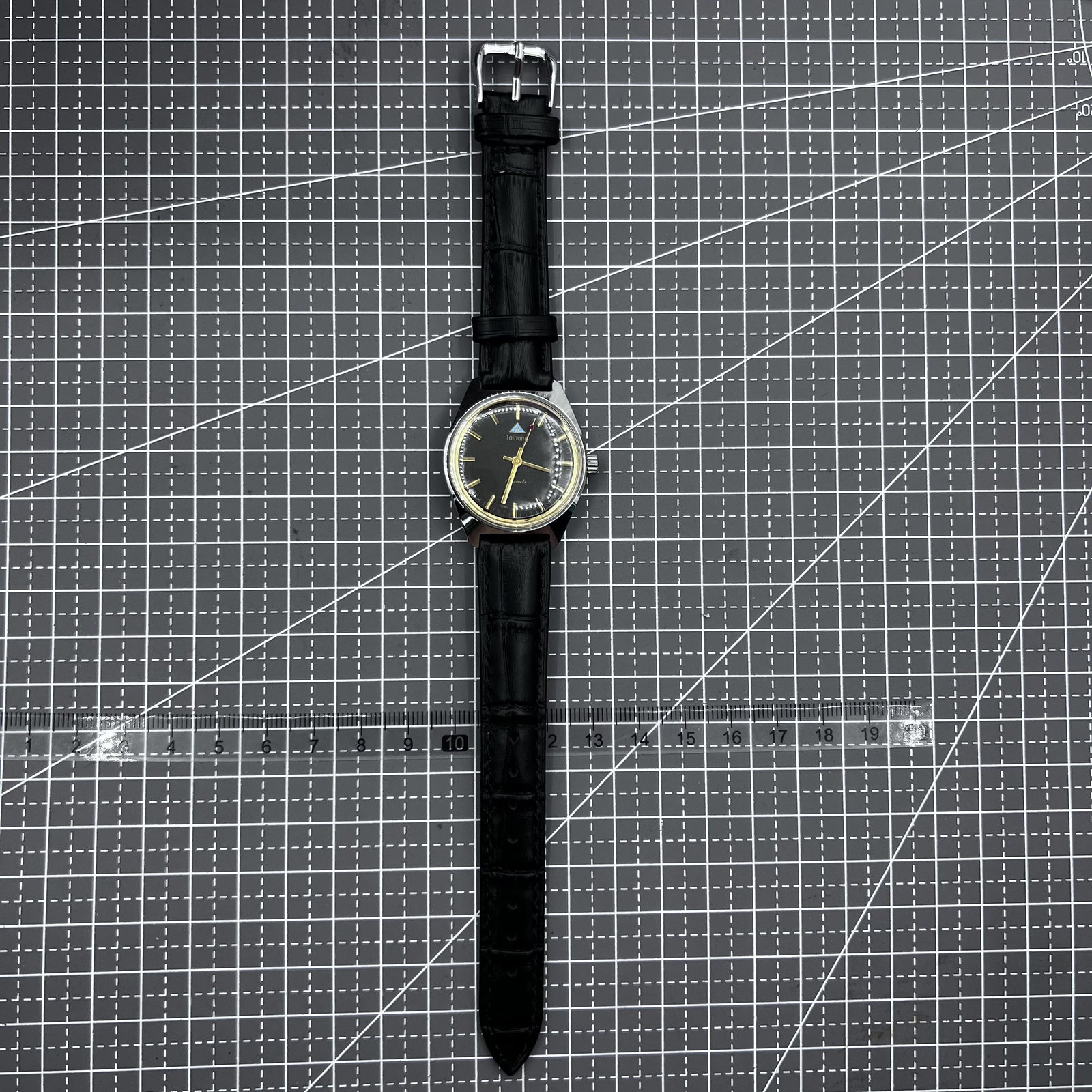 Taihang 32mm manual mechanical watch with black strap, golden nails, and black dial for classic style.