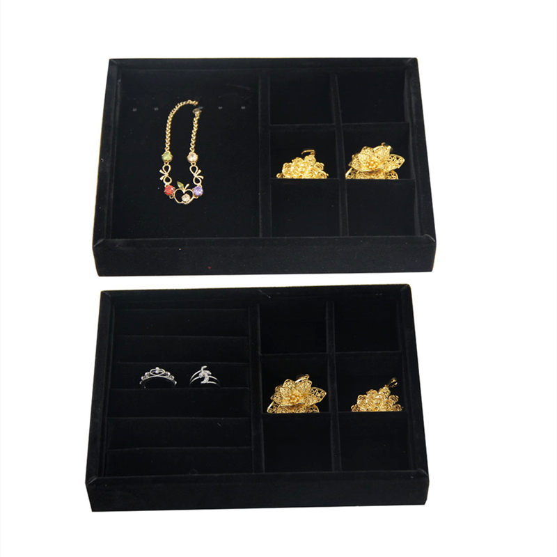 Gray velvet jewelry tray featuring grid compartments for stackable accessory storage.