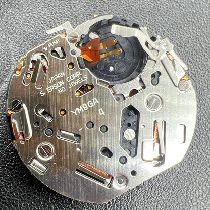 Hattori Epson YM9G quartz watch movement, precise timekeeping mechanism for watch repairs.
