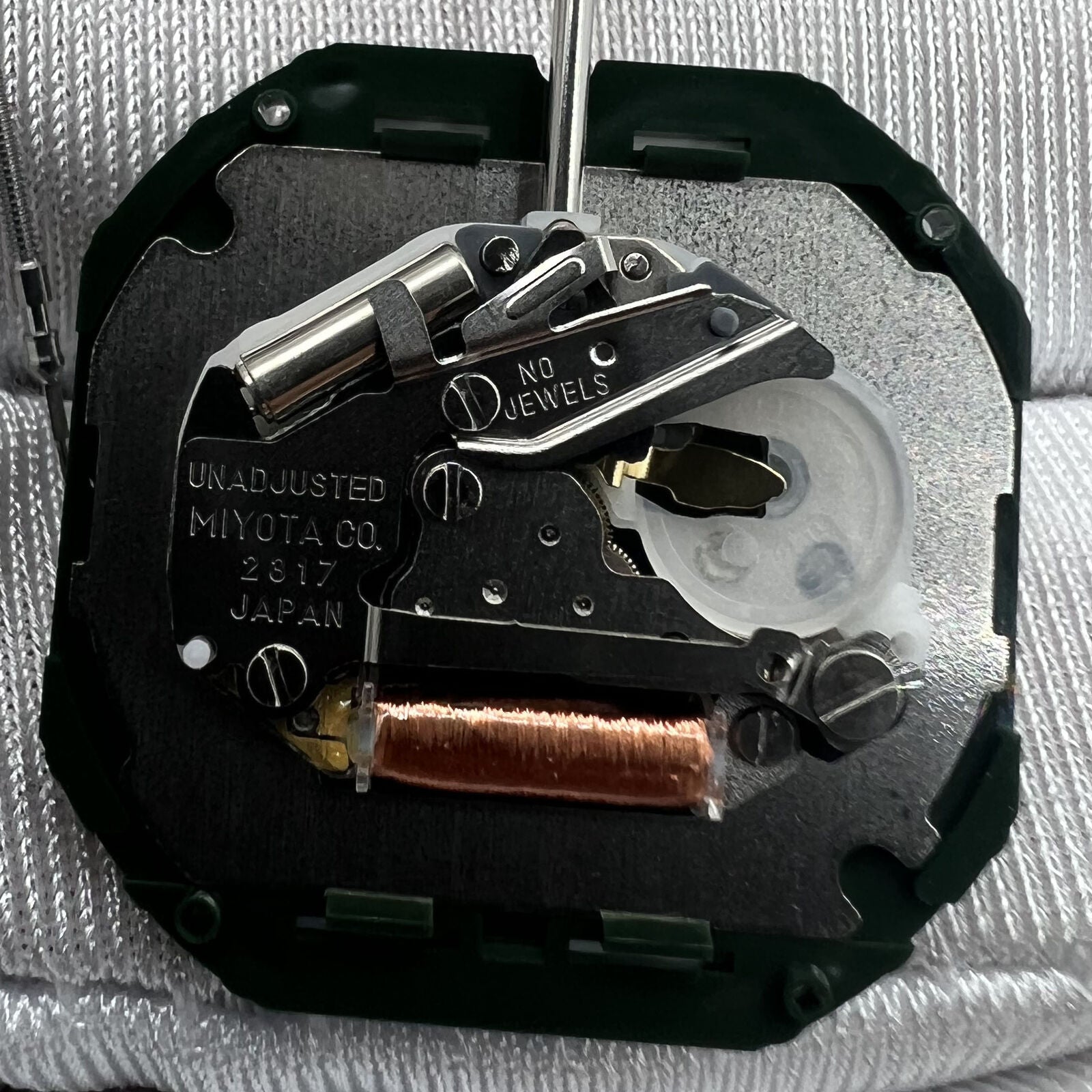 Japan Miyota 2317 quartz watch movement with date display at 3 o'clock, silver repair part for precision timekeeping.