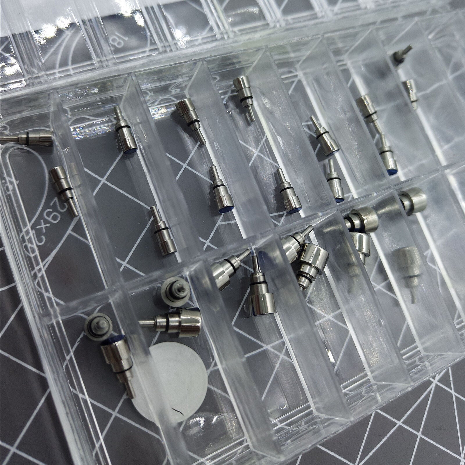 Classic stainless steel chronograph button set with 26 screw-in pushers for watch repair and customization.