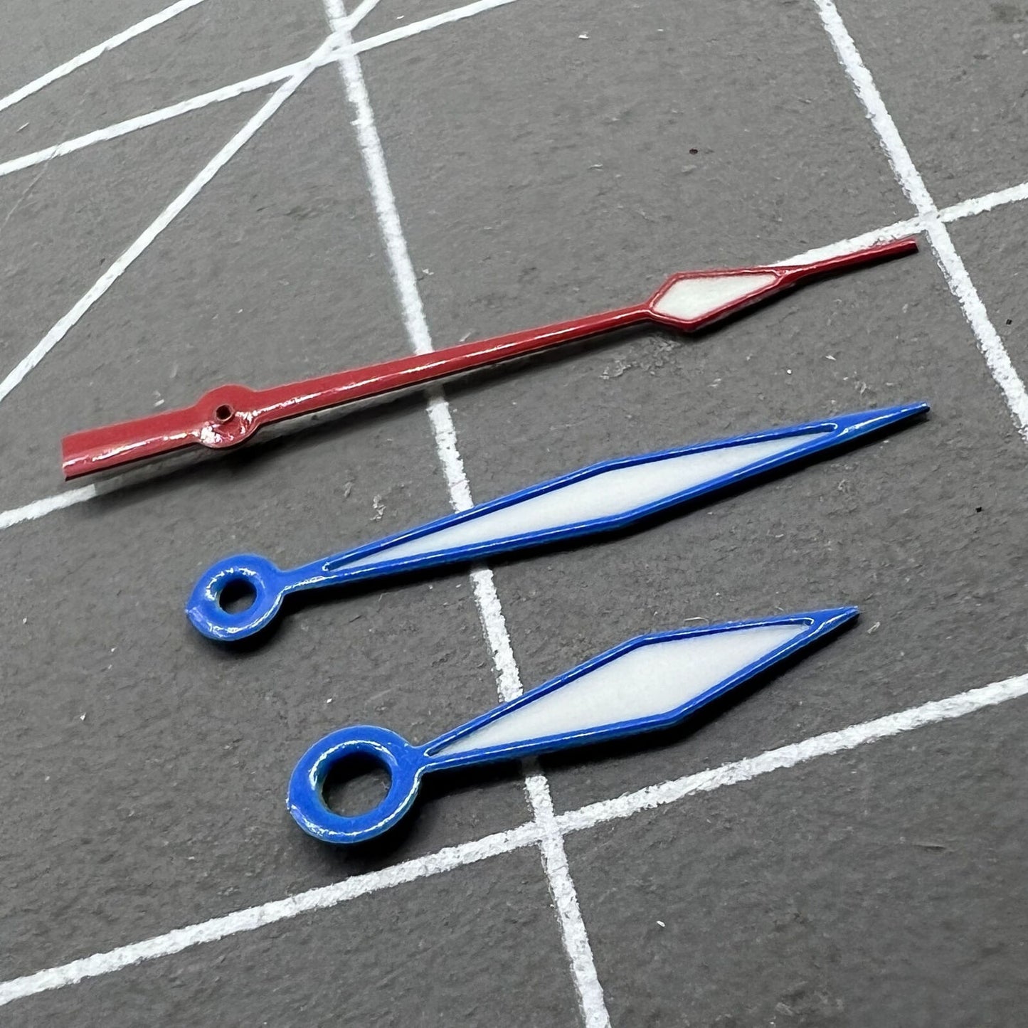 Diamond-shaped luminous watch hands with blue and red trim for Ronda 515 quartz movement, perfect for watch repair.