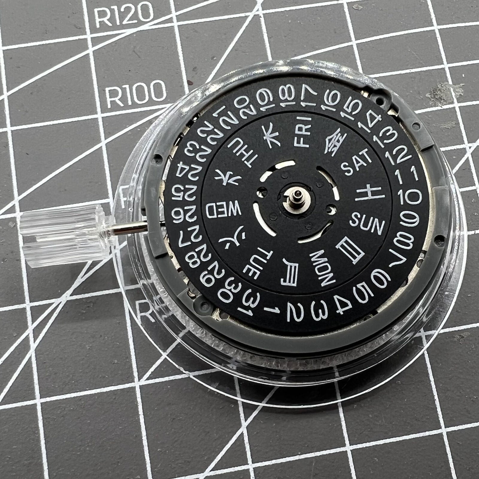 Miyota NH36A automatic watch movement with black finish and blue lume, crown positioned at 3:38.