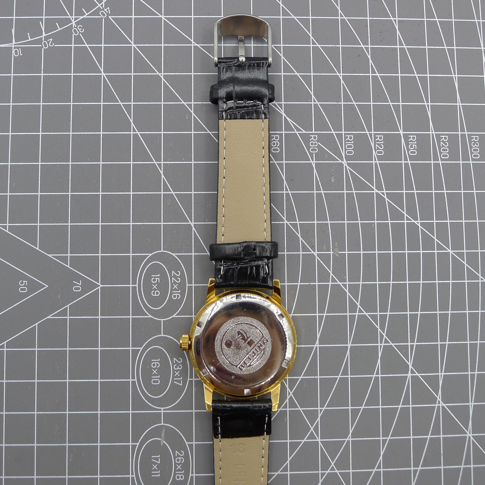 Beijing Double Rhomb watch featuring a golden case, silver nail markers, and classic manual mechanical movement.