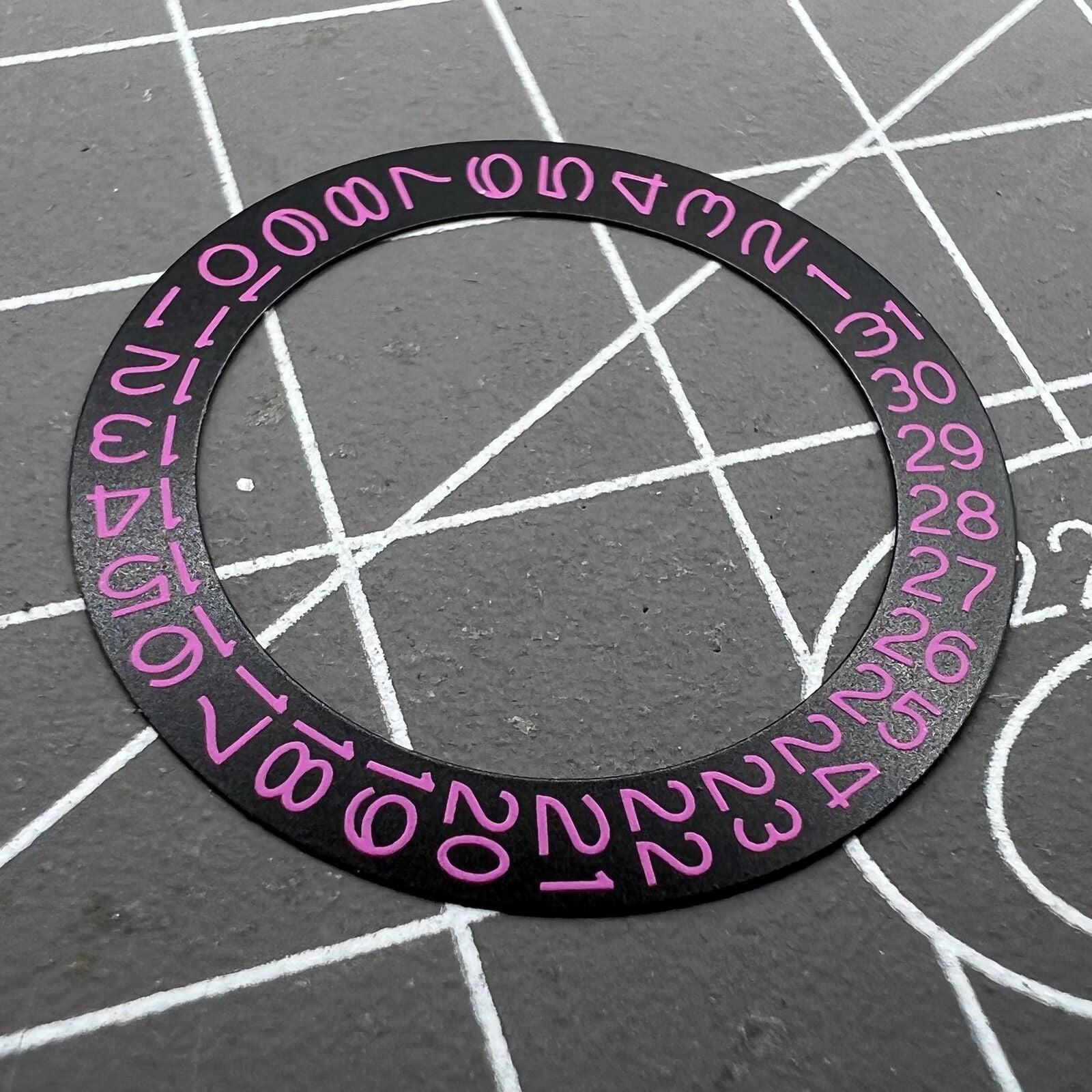 Pink character date disk overlay for NH35 NH36 watch movement on black background, enhancing brand recognition.
