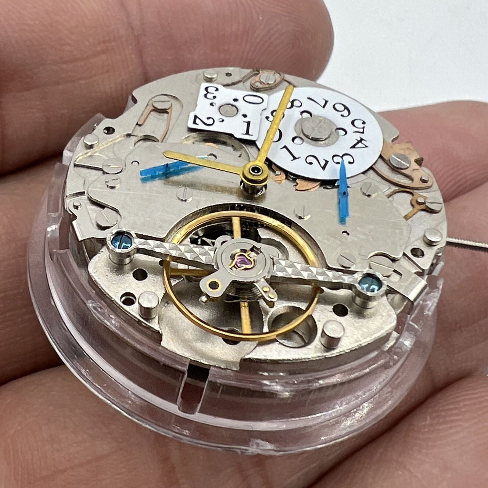 Asian brand multifunctional watch featuring date at 12 o'clock, bare balance wheel, and automatic mechanical movement.