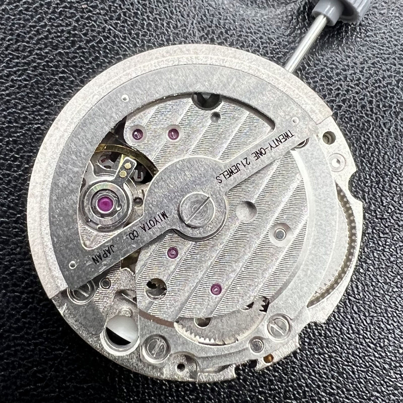 Miyota 8217 automatic watch movement displaying three hands with small seconds at 9 o'clock, precision gear mechanism.