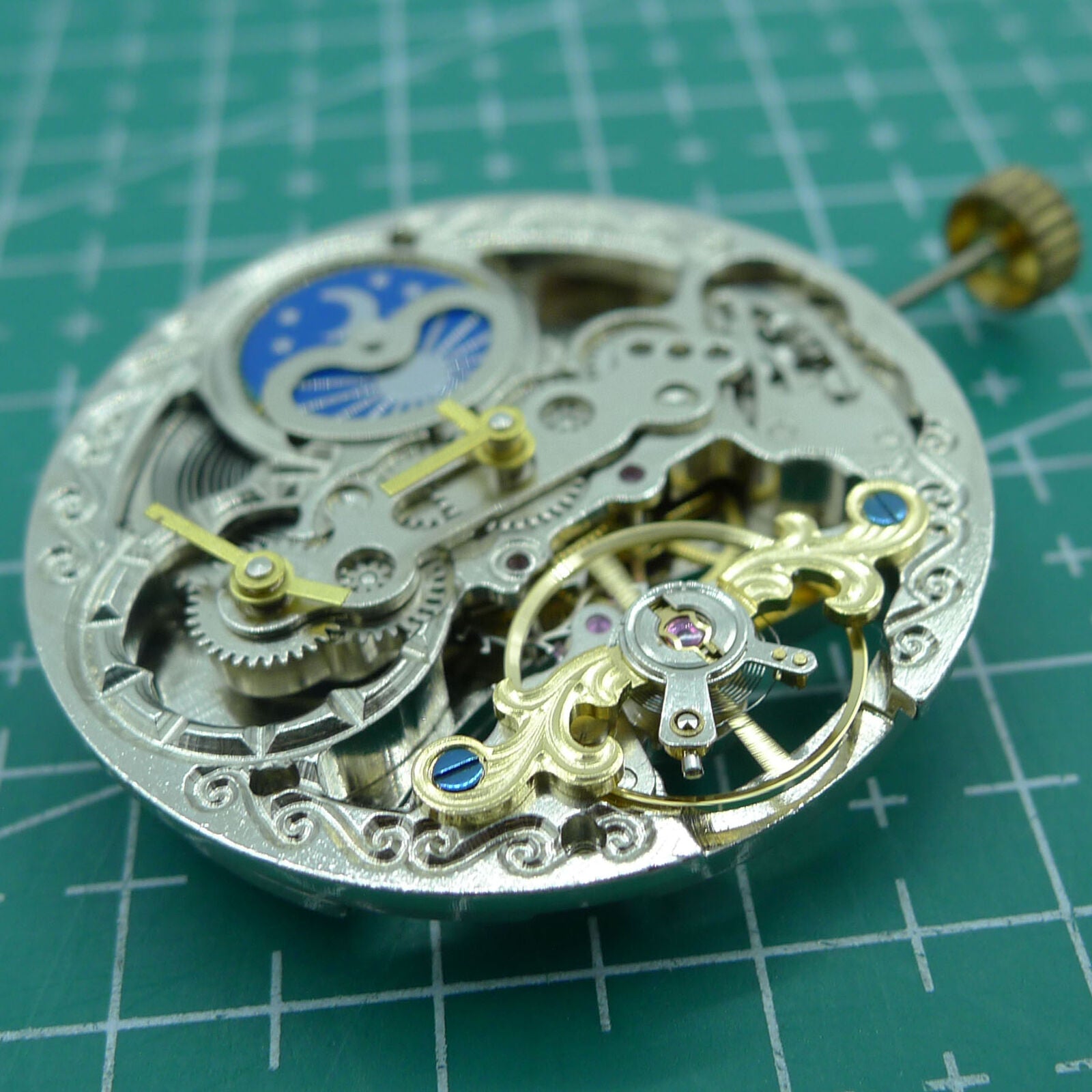 Silver automatic mechanical watch with hollow moon phase at 12 o'clock