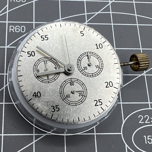 Close-up of China Made 7750 Automatic Chronograph Movement with ETA 7753 layout showing detailed gears at 3, 6, and 9 o'clock positions.