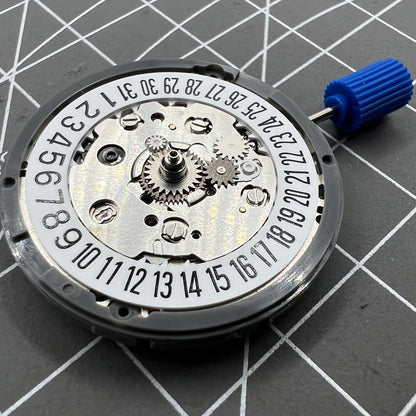 NH34 automatic mechanical GMT watch movement with hacking seconds and date at 6, featuring a white disk wheel.