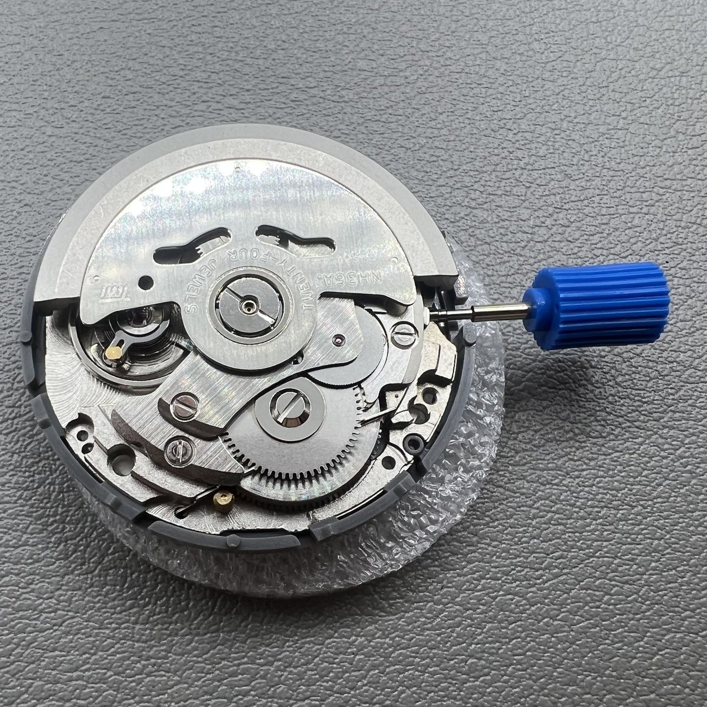 Seiki NH36 watch movement with white dial, featuring Japanese-English day display for precision timekeeping.