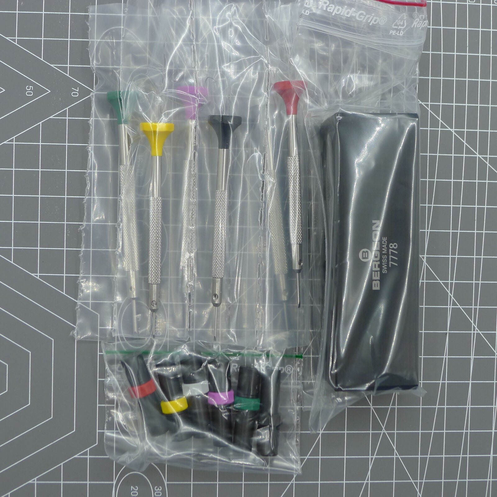 Swiss Bergeon 7778 watch screwdriver set with 6 precision blades, spare tips, and organizer stand for watch repair.