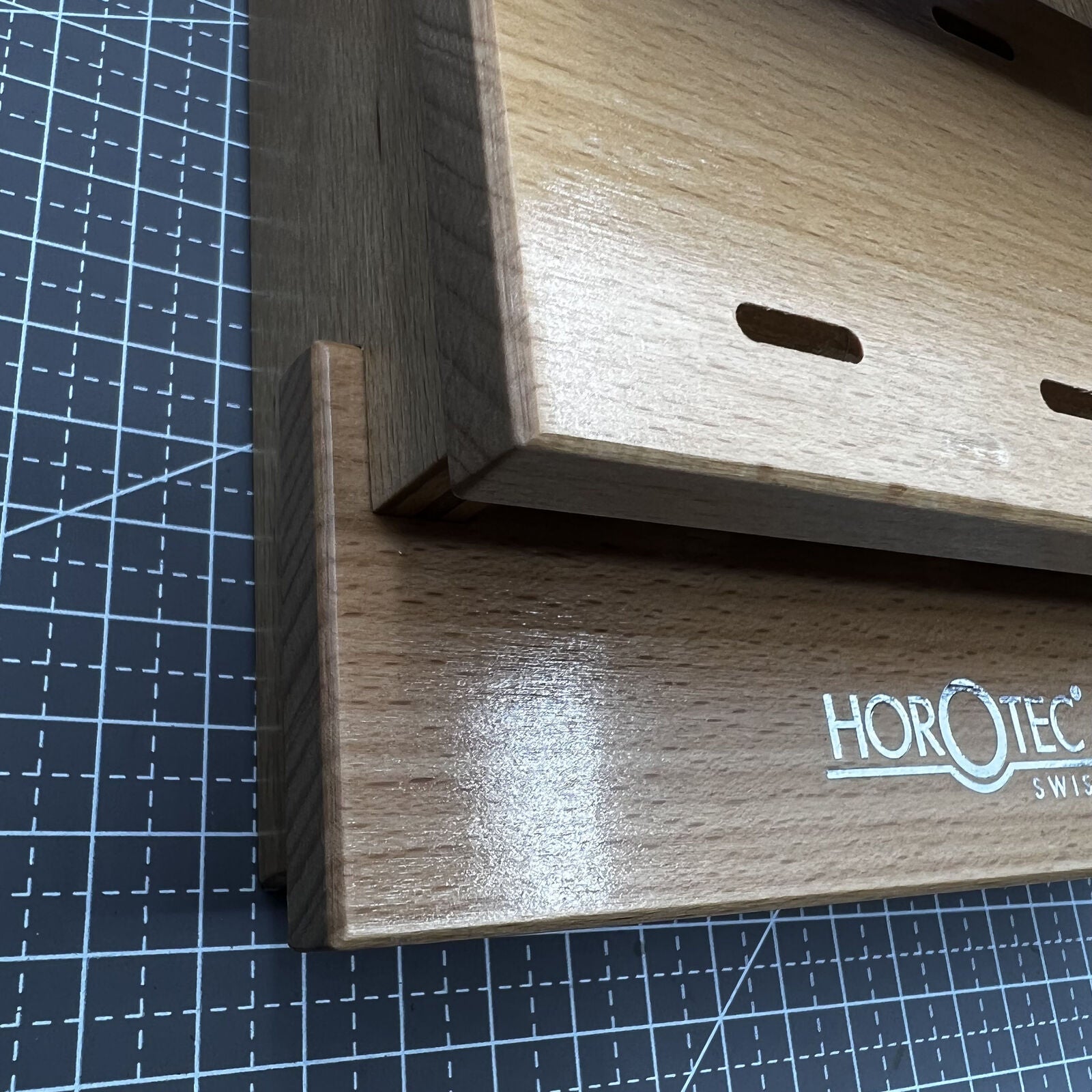 Swiss Horotec wooden storage rack neatly holding 12 precision tweezers for organized watch repair tools.