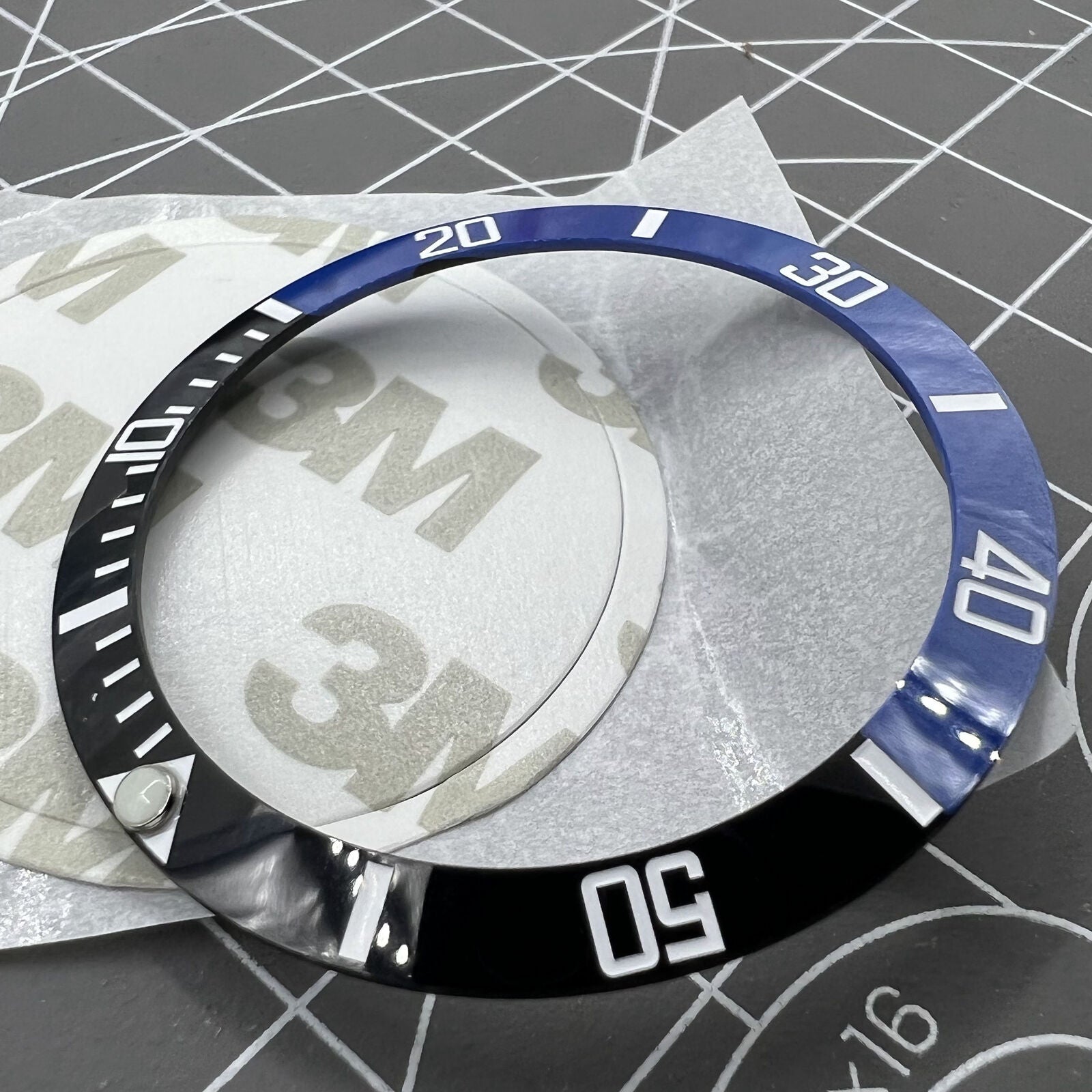 38mm Ceramic black and blue bezel with green lume and silver font for watch customization.