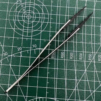 Precision stainless steel tweezers with carbon fiber tips for detailed watch repair.