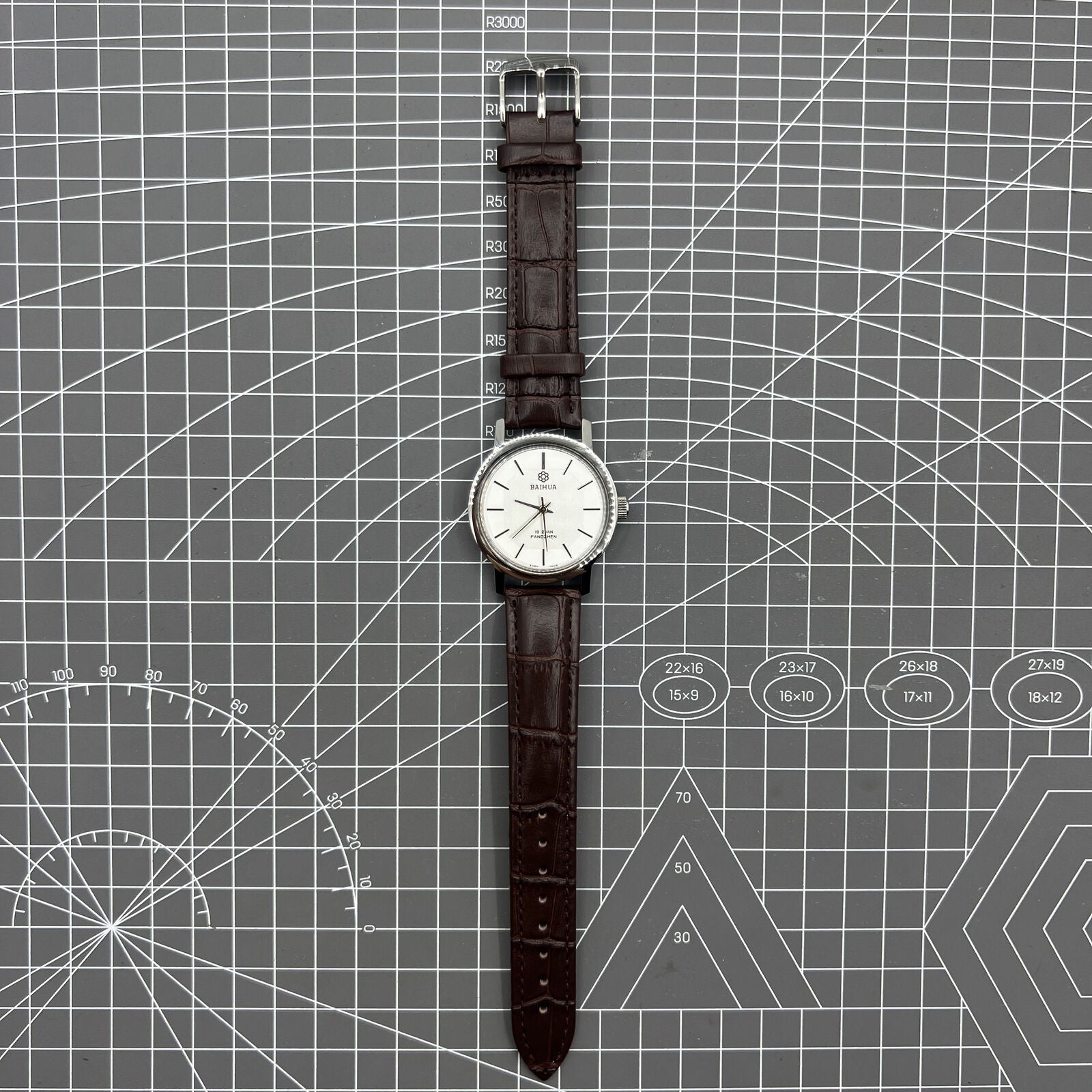 China Baihua 37mm manual mechanical watch with silver dial, 19 jewels, and shock-resistant design.