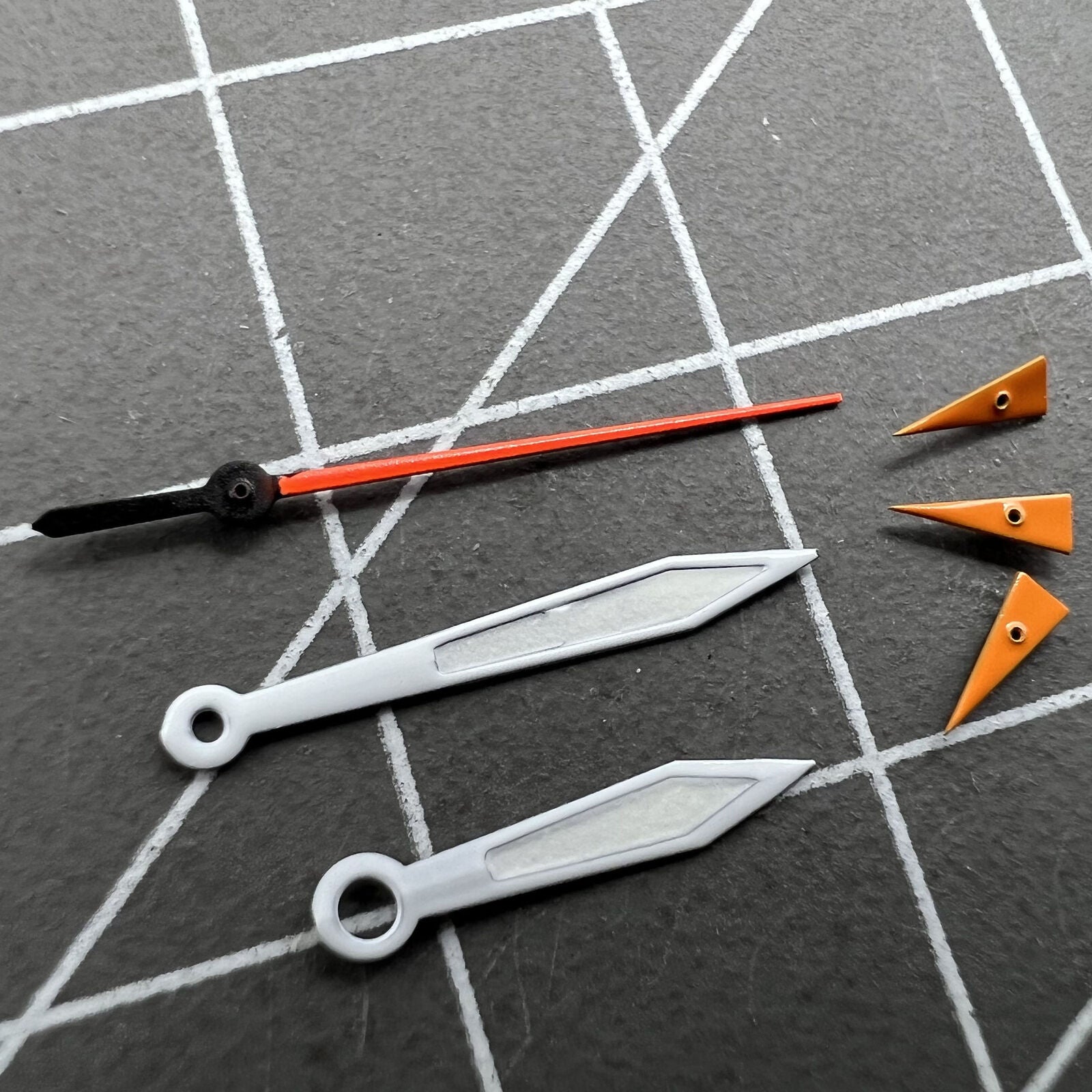 Orange 14mm watch hands with silver trim and green luminous centers, compatible with Miyota 0S10 movement.