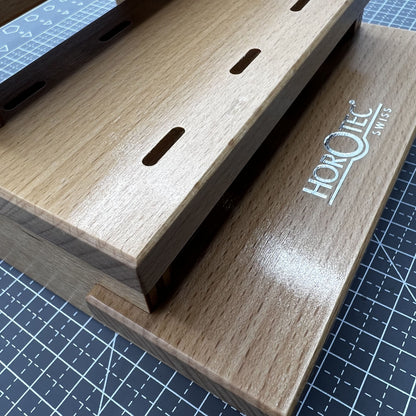 Swiss Horotec wooden rack holding 12 precision watchmaker tweezers for organized watch repair workstation.