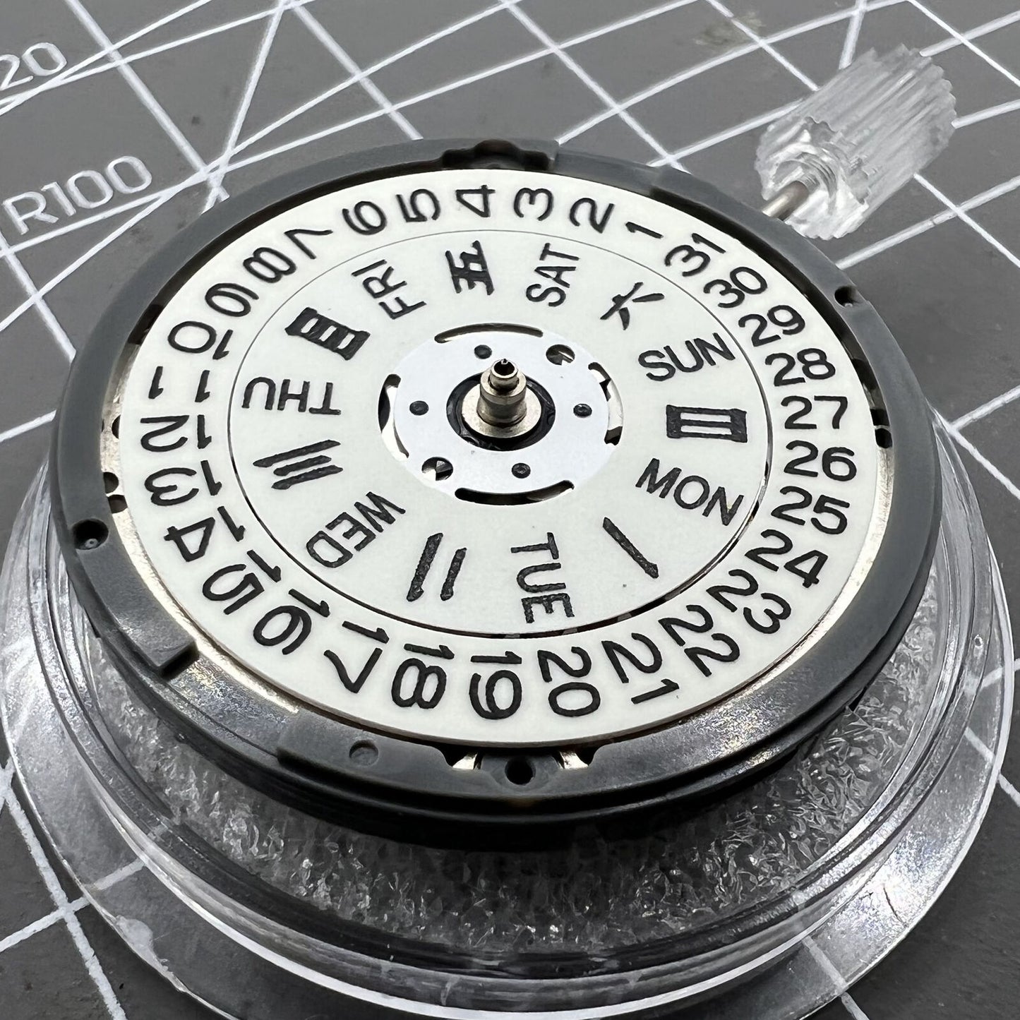 Miyota NH36A automatic watch movement with white dial, blue lume, and triple crown positions for precision adjustments.
