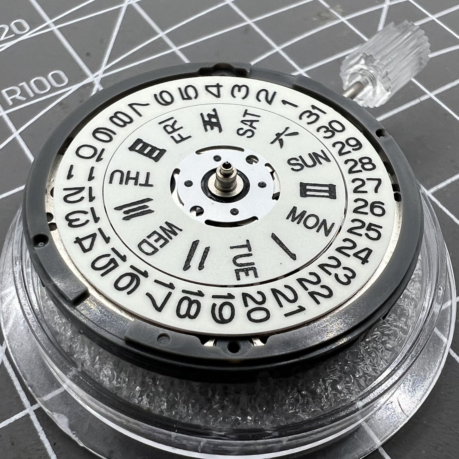 Miyota NH36A automatic watch movement with white dial, blue lume, and triple crown positions for precision adjustments.