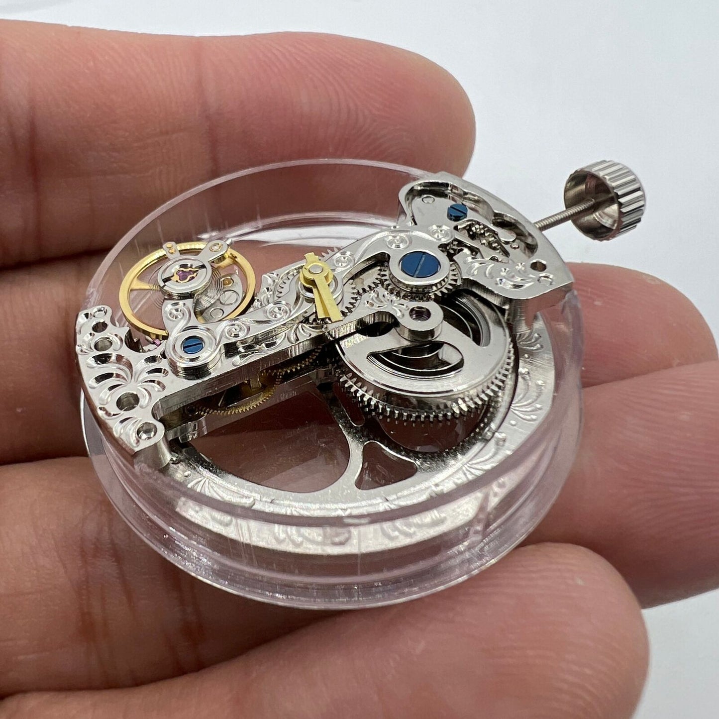 Silver long pendulum wheel watch accessory by Asian, automatic mechanical movement detail visible