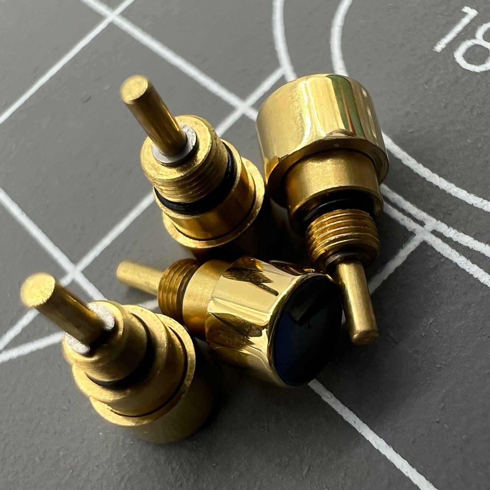 Set of 14 golden stainless steel watch pushers in 7 sizes, durable for drive-in type repairs.