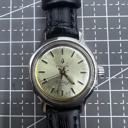 27mm Kongque watch with black leather strap, silver dial, gold markers, manual mechanical movement, and 19 jewels.