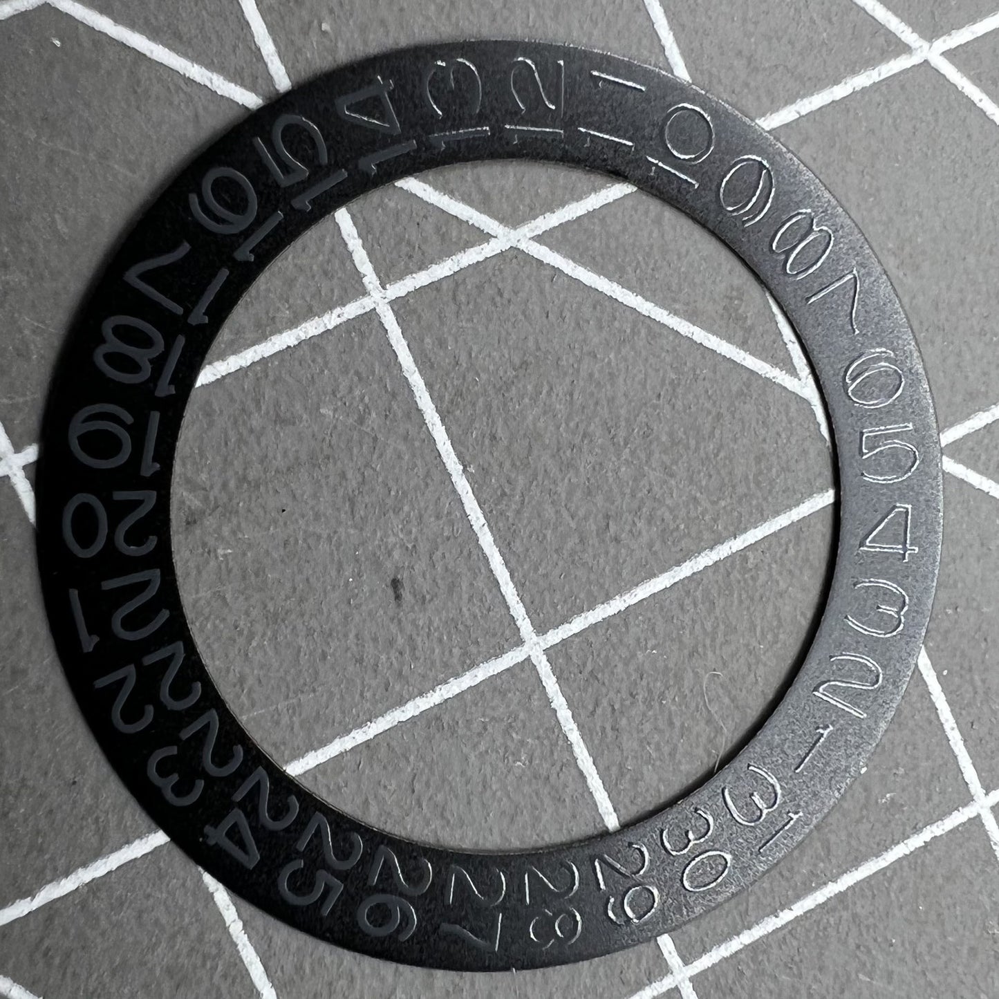 Black background close-up of Grey Character Date Disk for Seiko NH35 NH36 watch movement.