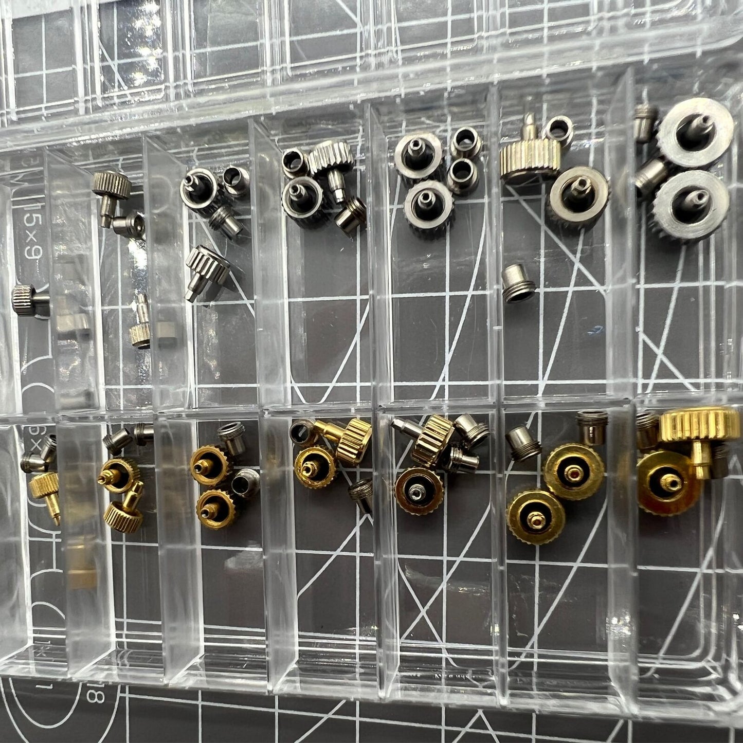 Stainless steel watch crown with dual silver and gold tones, screw-on tube, and gasket for secure fit.