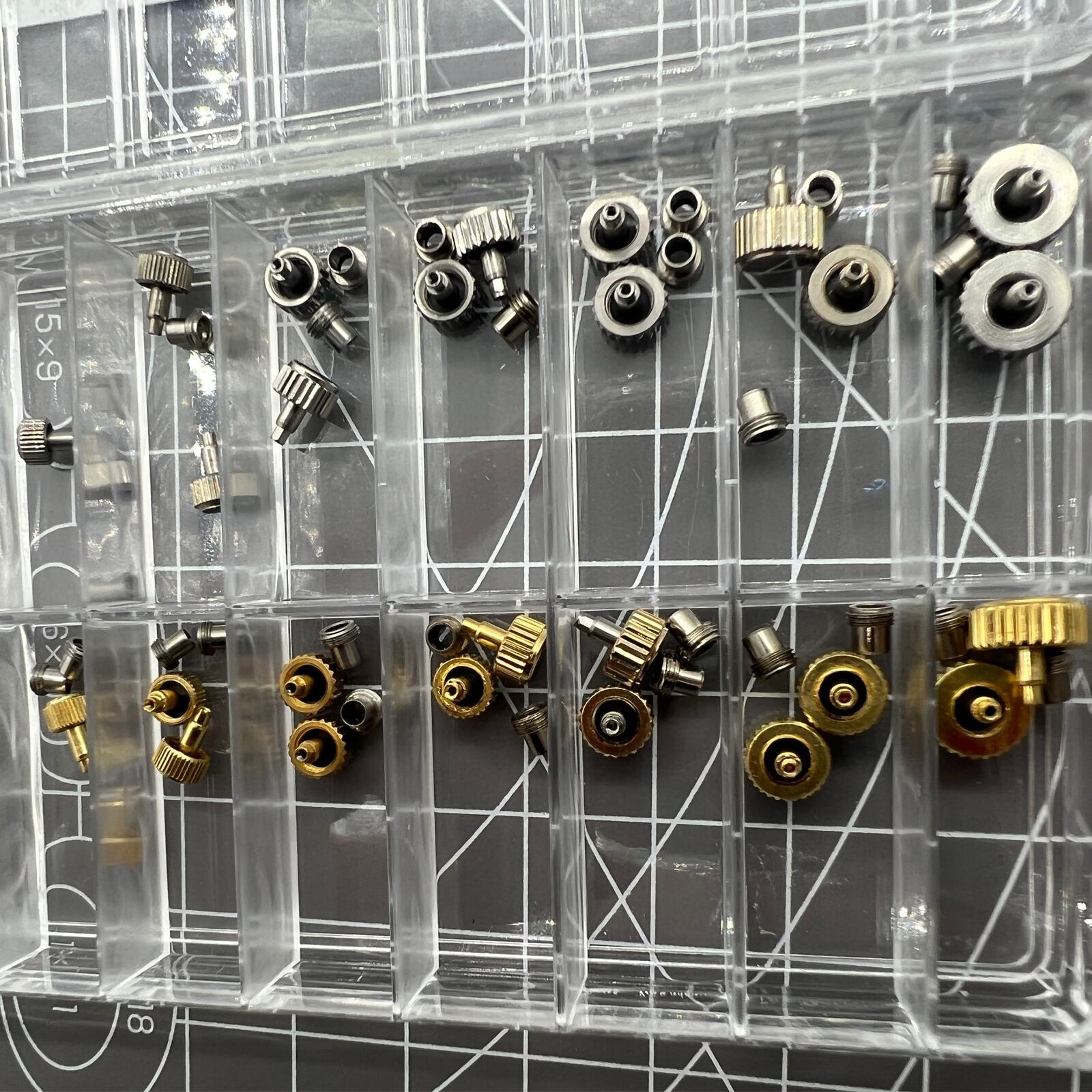 Stainless steel watch crown with dual silver and gold tones, screw-on tube, and gasket for secure fit.