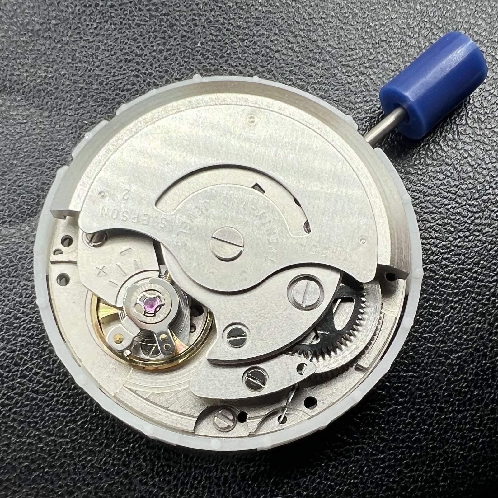 Japan Epson YN55 mechanical watch movement with single calendar, showcasing intricate gear details and precision engineering.