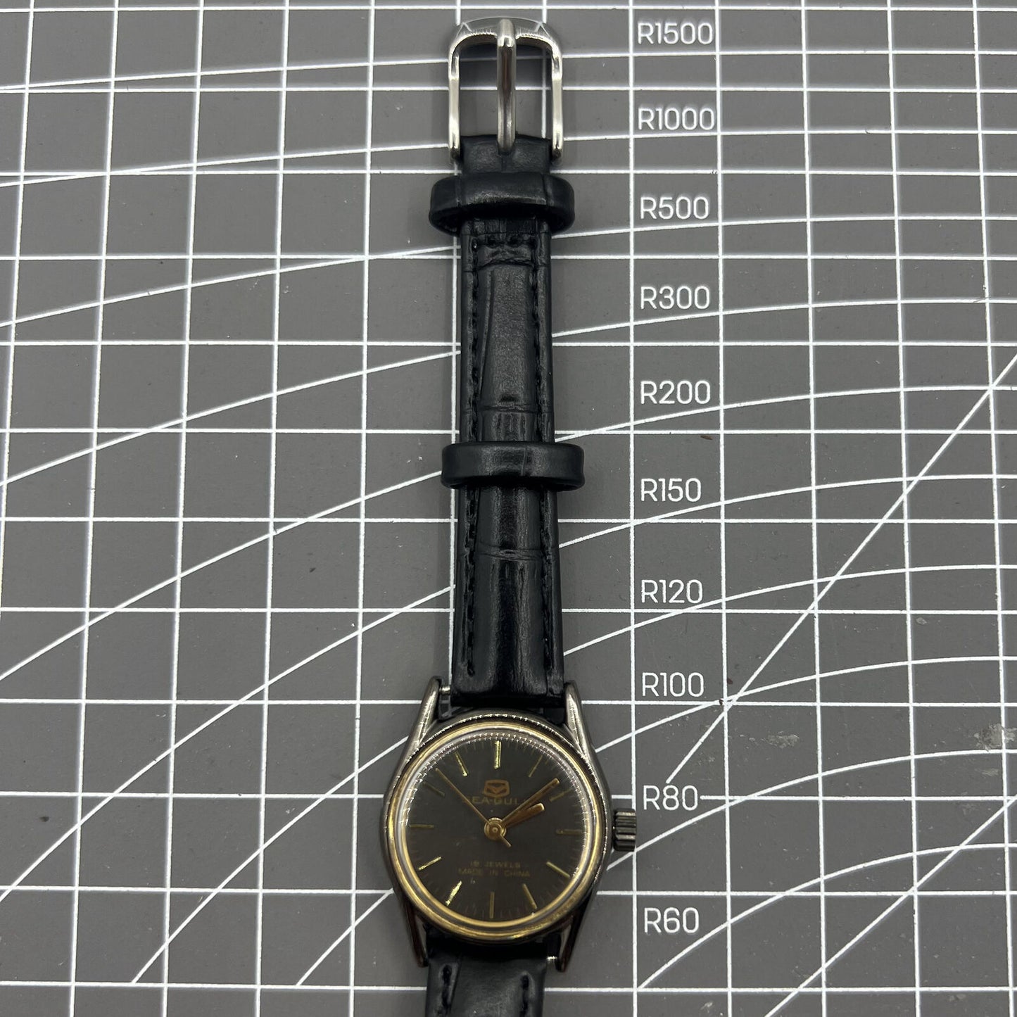 Seagull black case ladies watch with golden nail markers, manual mechanical movement, and shock-resistant build.