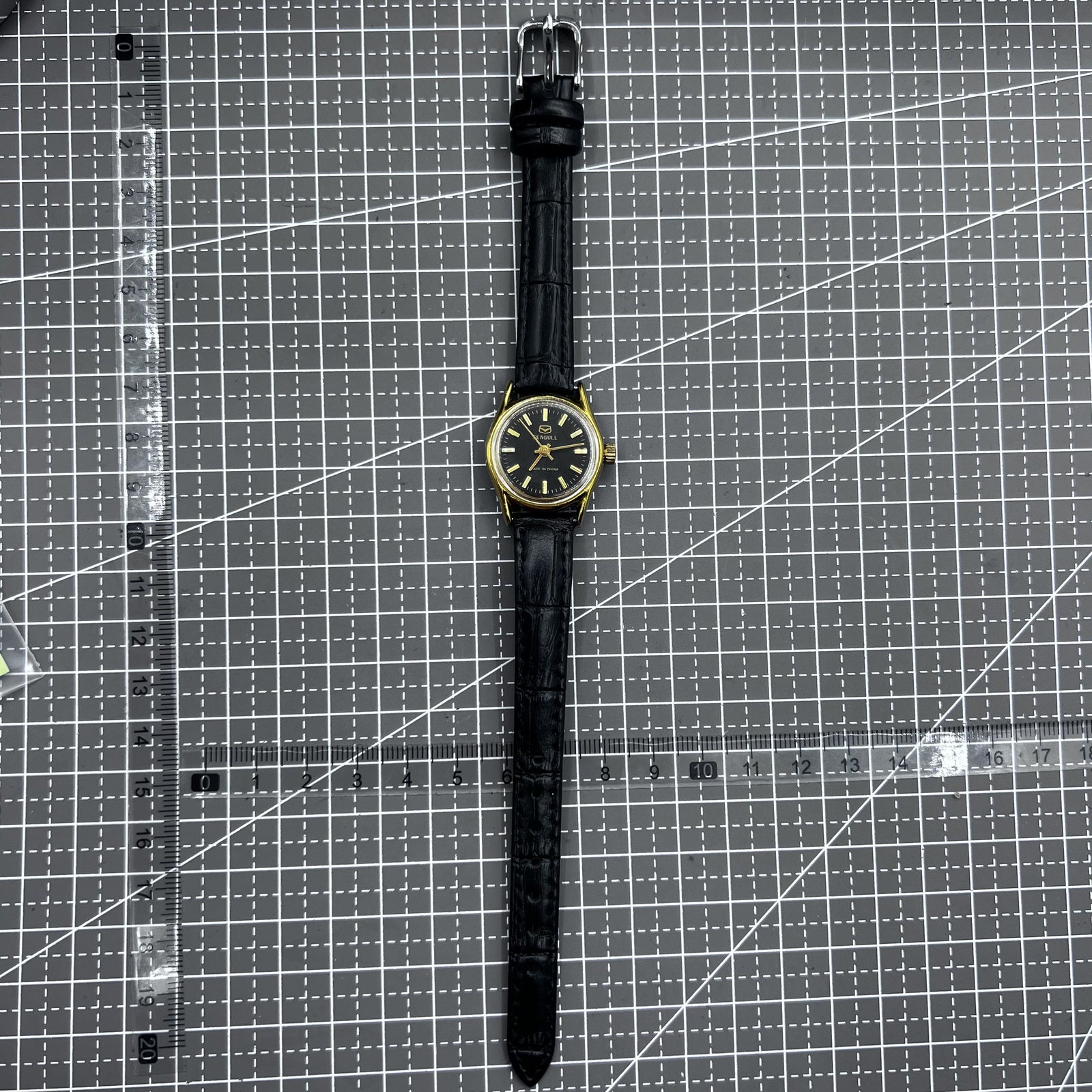 Black round case ladies watch with golden nails, Tianjin Seagull manual mechanical movement, elegant design.