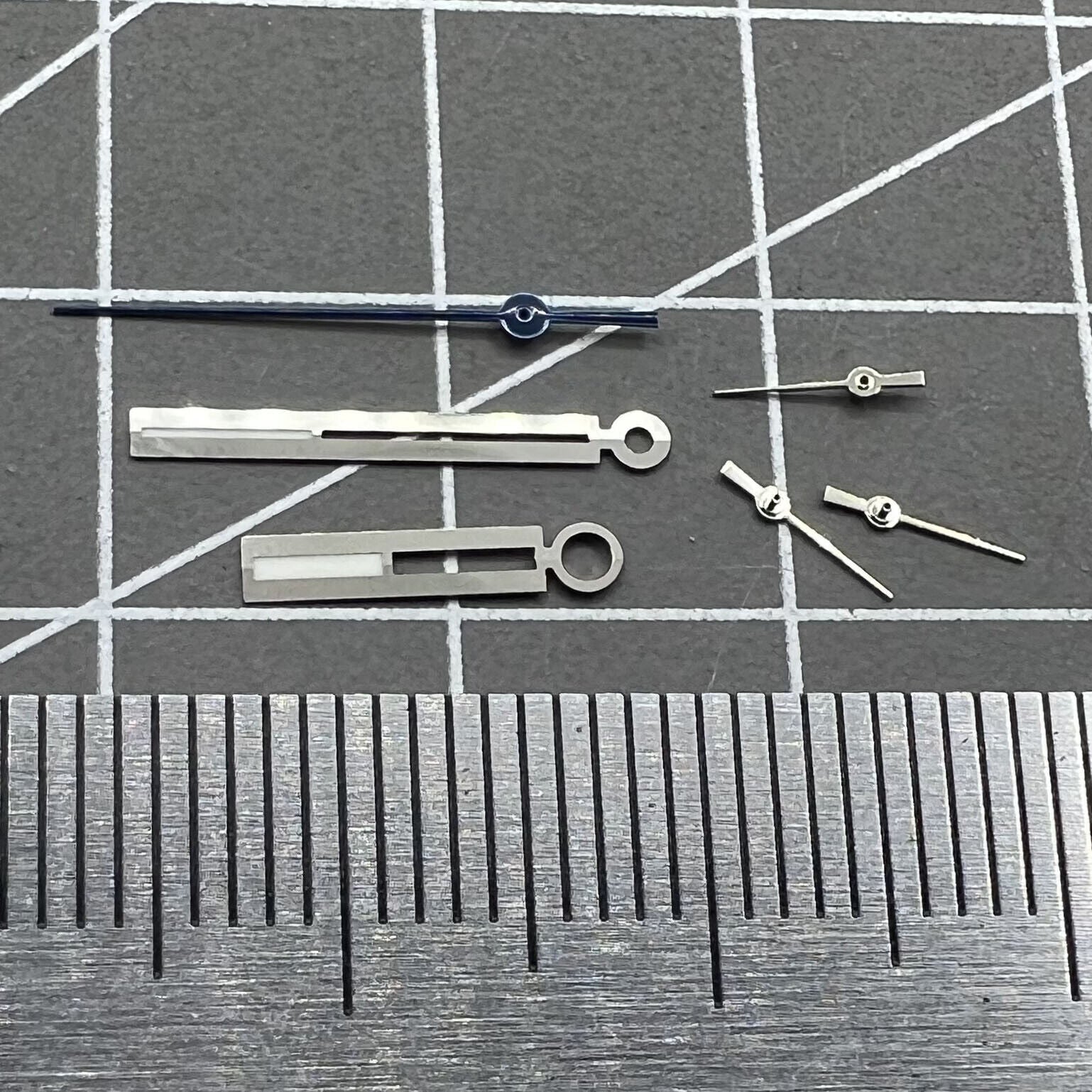 Luminous silver watch hands, designed for Ronda 5021D quartz movement, ensuring clear time reading in dim conditions.