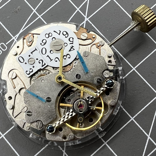 Multifunctional Date@12 watch with bare balance wheel, automatic mechanical movement, showcasing precision.