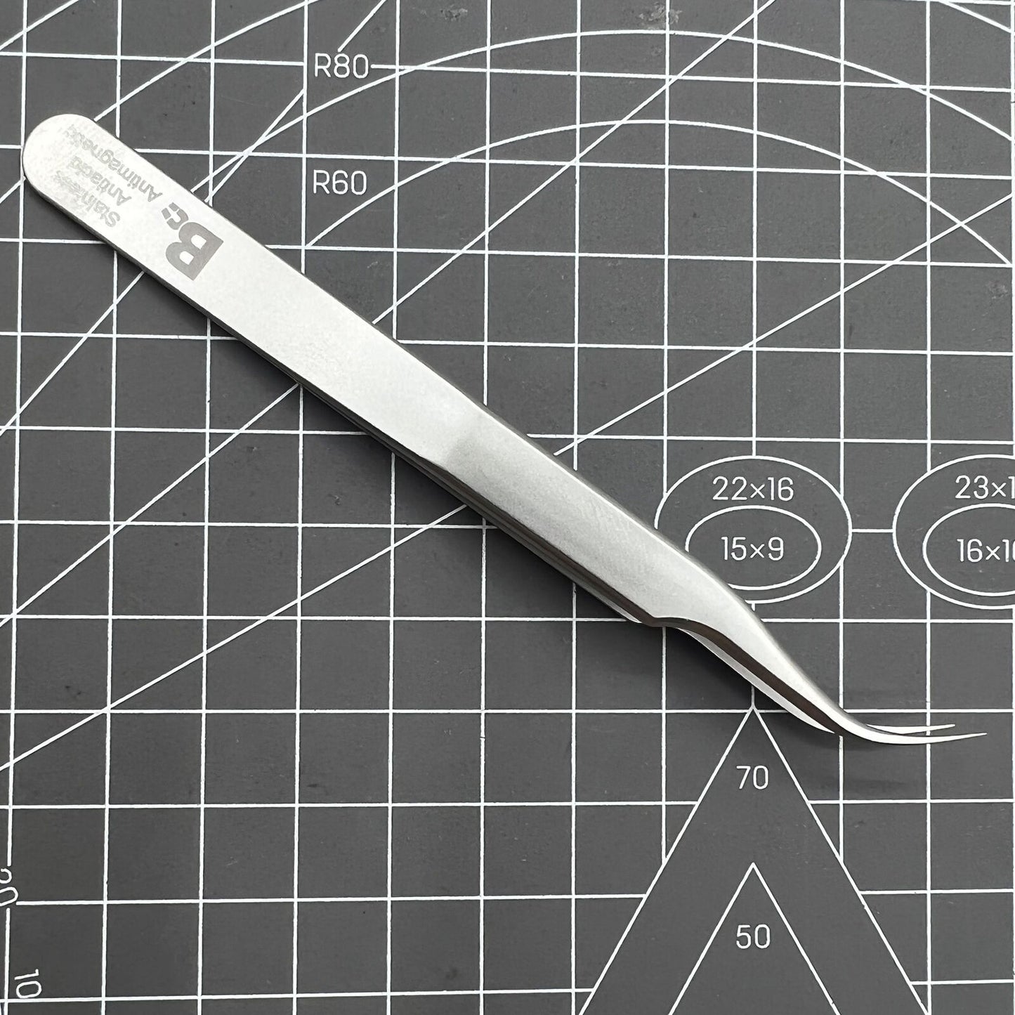 Swiss Bergeon 7026-7 antimagnetic curved tweezer for precise handling of delicate watch accessories.