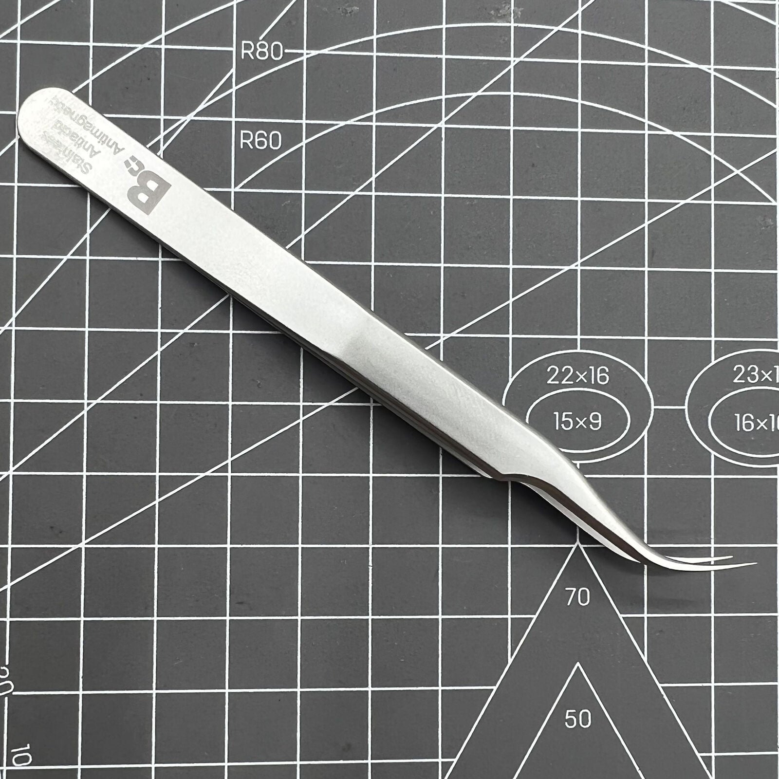 Swiss Bergeon 7026-7 antimagnetic curved tweezer for precise handling of delicate watch accessories.