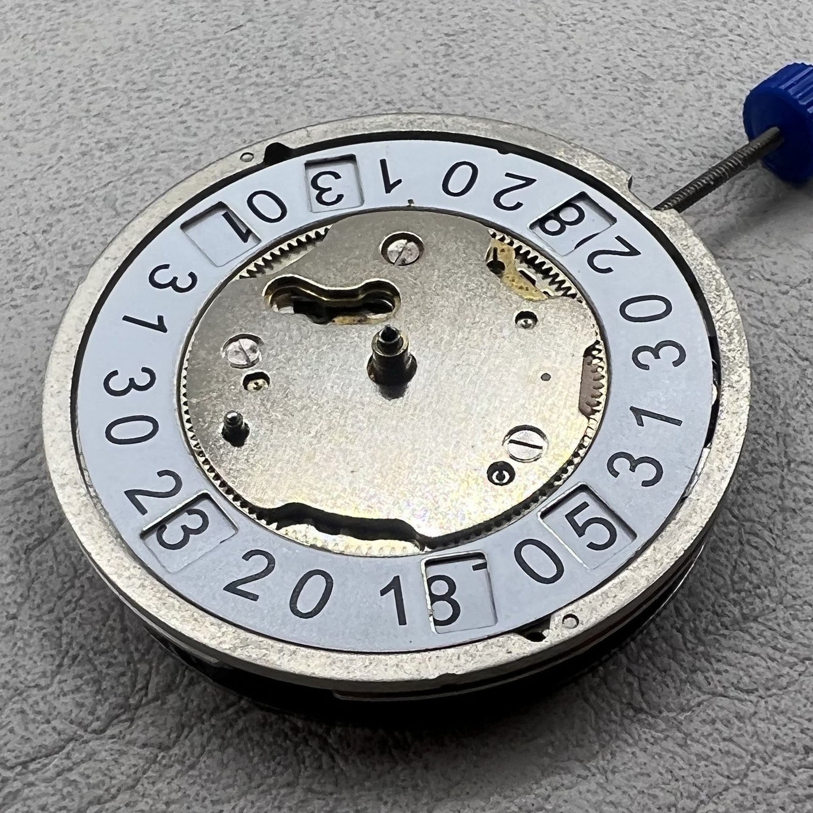 Swiss Ronda 5050B quartz watch movement with date at 6 o'clock and three hands for precise timekeeping.