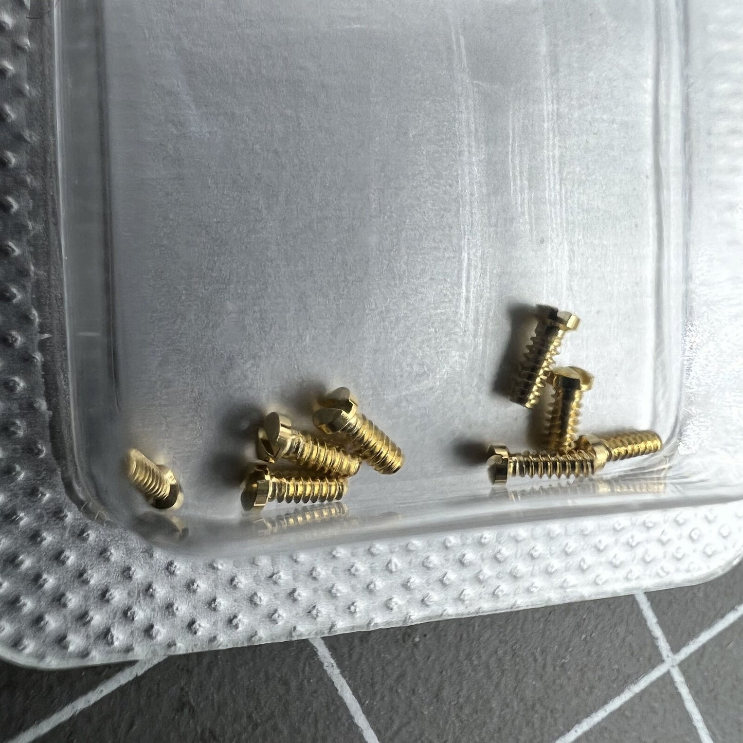 Golden 3x1mm slotted back cover screws for Cartier men's watches, durable watch accessory.