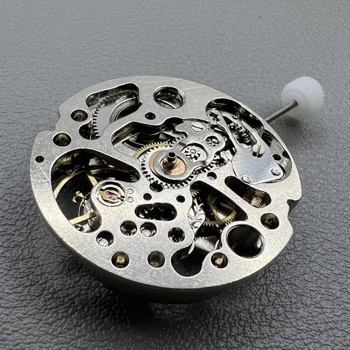 7120 Hollow silver automatic watch movement displaying intricate mechanical gears and expert craftsmanship.