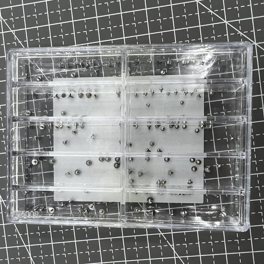 Assortment of watch movement fixing screws in various sizes for precise repairs and adjustments.