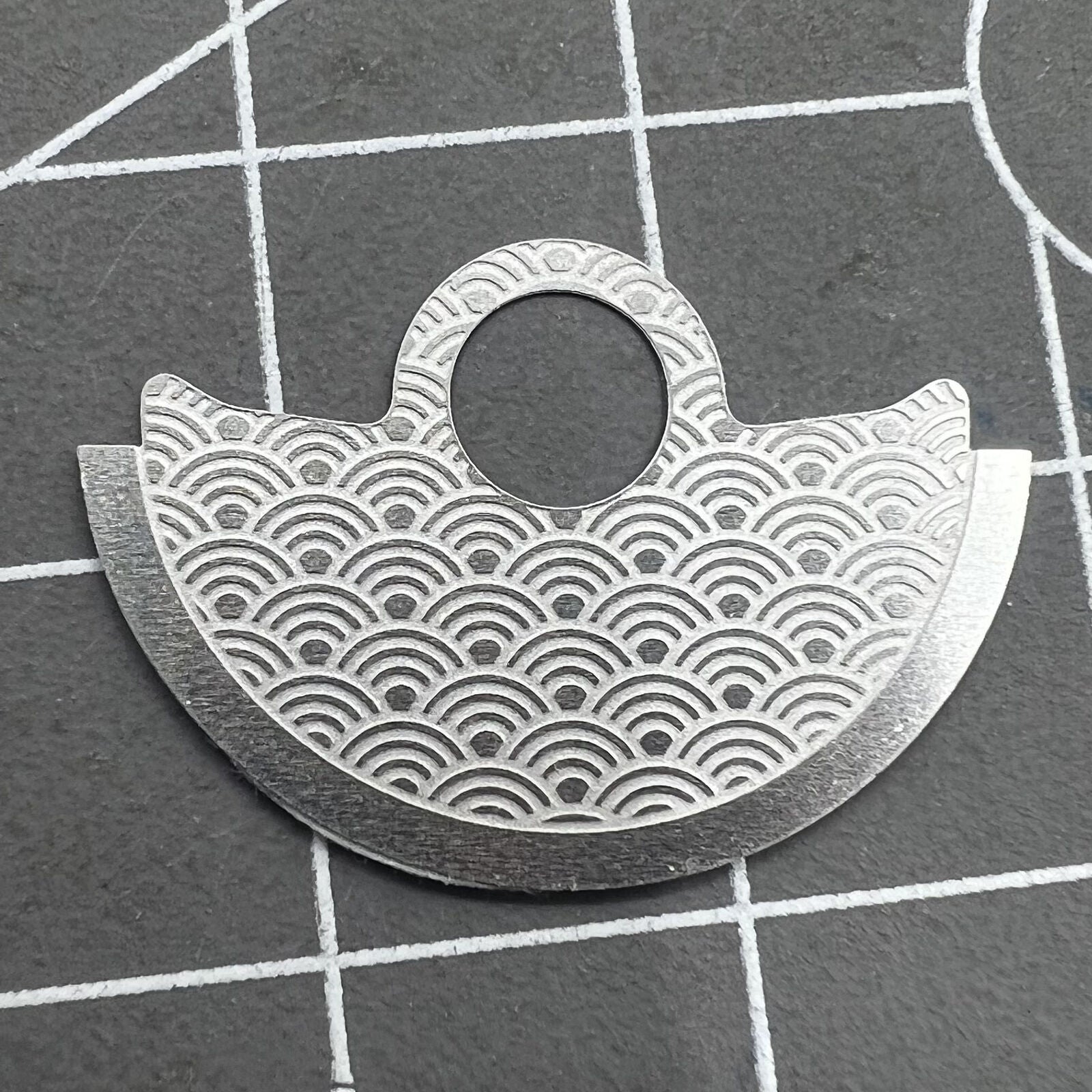 Waved silver metal sheet overlay on Miyota 9015 rotor hammer, enhancing watch movement design and durability.