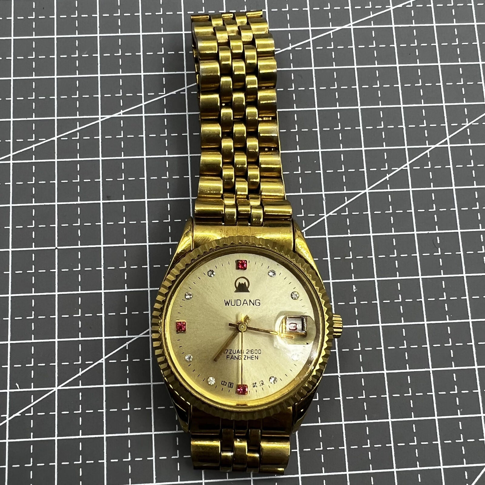 38mm Wudang Steel mechanical watch with golden dial and single calendar, 17 jewels, elegant design.