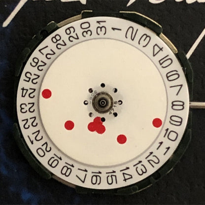 Miyota 2105 quartz watch movement with white dial and red hour markers for precise timekeeping.