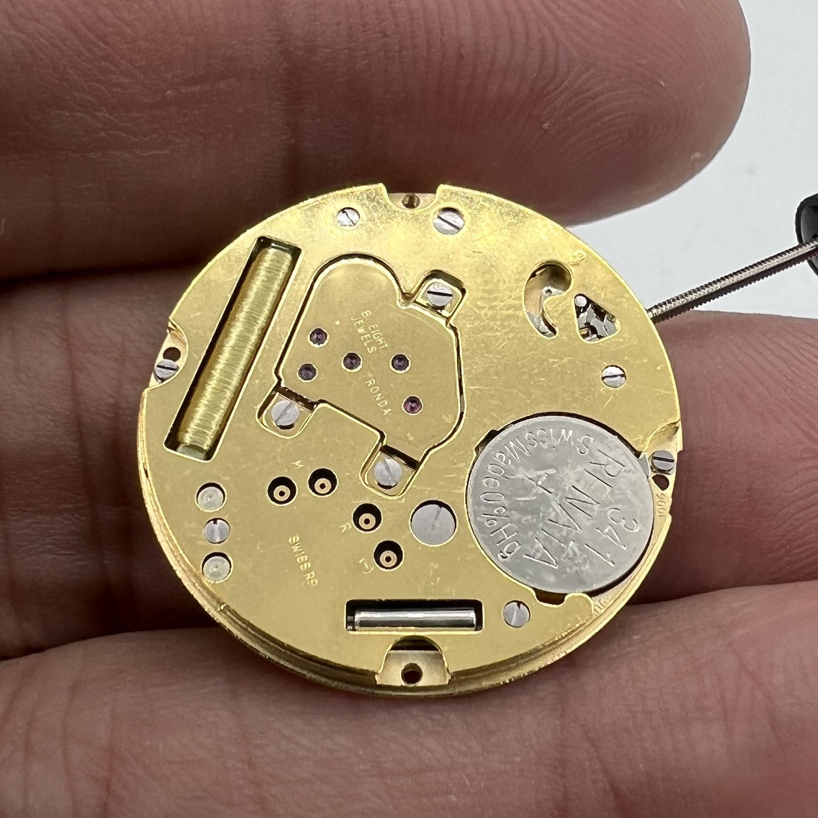 Swiss Made Ronda 1006 Slimtech golden quartz watch movement with date display at 6 o'clock for precise timekeeping.