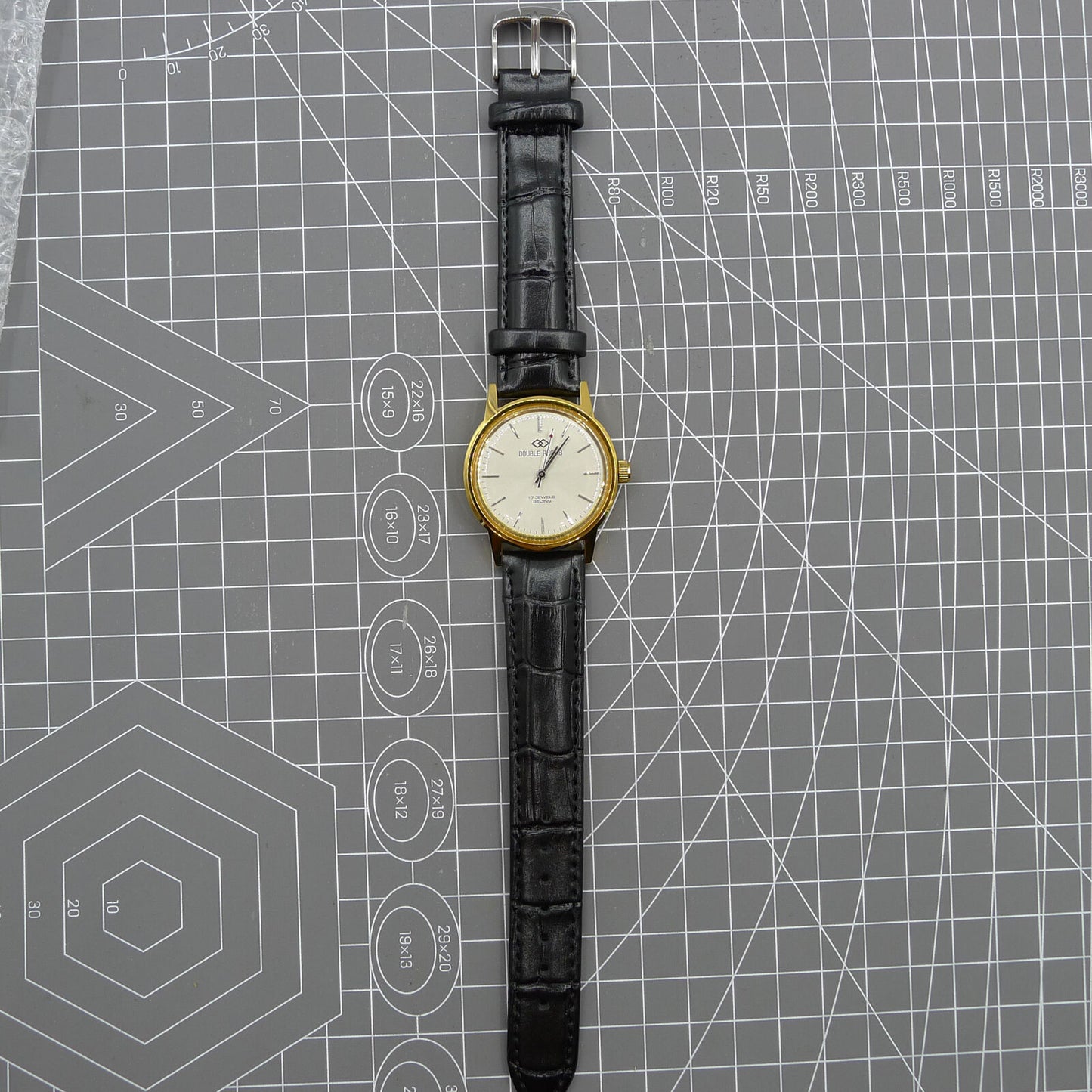Beijing Double Rhomb watch with golden case, silver nail markers, and manual mechanical movement for classic style.