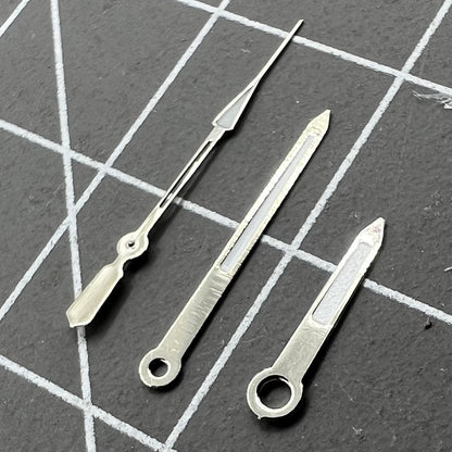 Silver-trimmed 14mm watch hands with green lume, fits Ronda 515 quartz for stylish timekeeping.