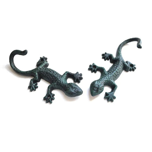 Vintage cast iron gecko-shaped wall hook for hanging cloth or garden tools, durable and rustic.