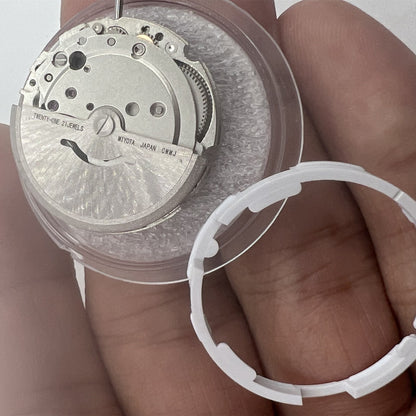 Miyota/Citizen 8215 automatic watch movement with black dial and date window at 6 o'clock.